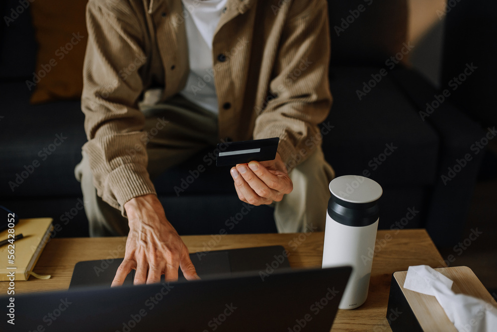 A man makes an online purchase on a laptop using a credit card. Concept photo 