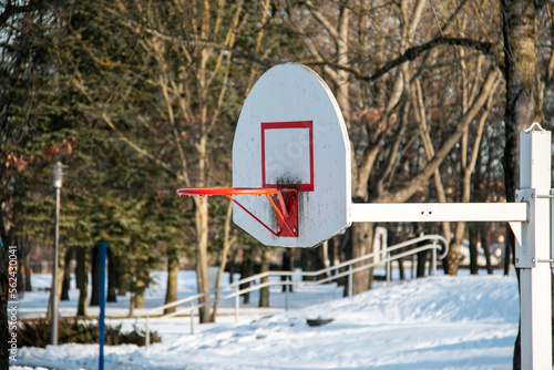 Basketball backboard with a ring in the park in winter on a background of snow. Basketball in winter.