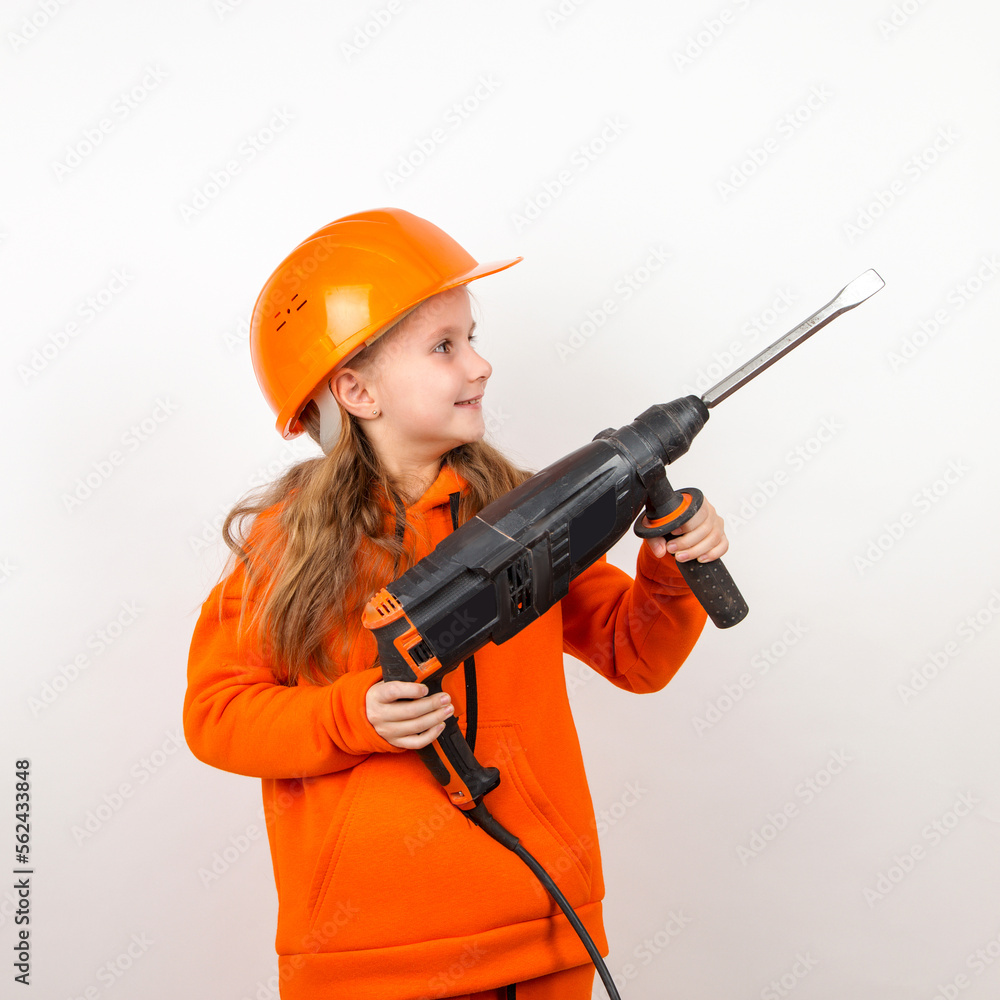Little girl in an orange suit and construction helmet, holding puncher, concept of young worker. Portrait, child builder, white background, Labor Day. Little girl in an orange suit and construction helmet, holding puncher, concept of young worker. Portrait, child builder, white background, Labor Day.
