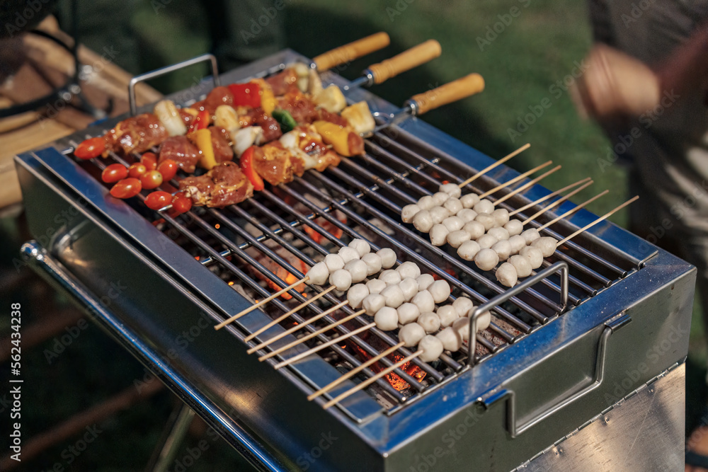 Barbeque skewers meat with vegetable and meatball grilling on charcoal bbq grill in backyard Barbeque skewers meat with vegetable and meatball grilling on charcoal bbq grill in backyard