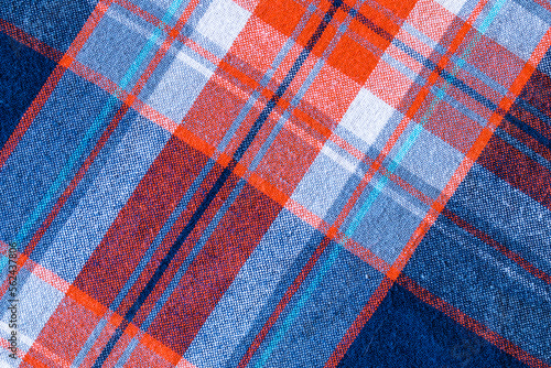 Orange, white, blue texture background. Shirt fabric with a checkered pattern. Factory material.