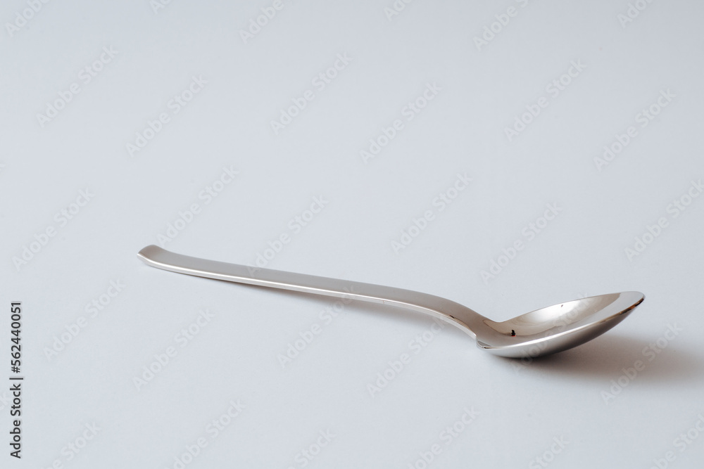 Silver shiny spoon on white background, kitchenware, copy space Silver shiny spoon on white background, kitchenware, copy space