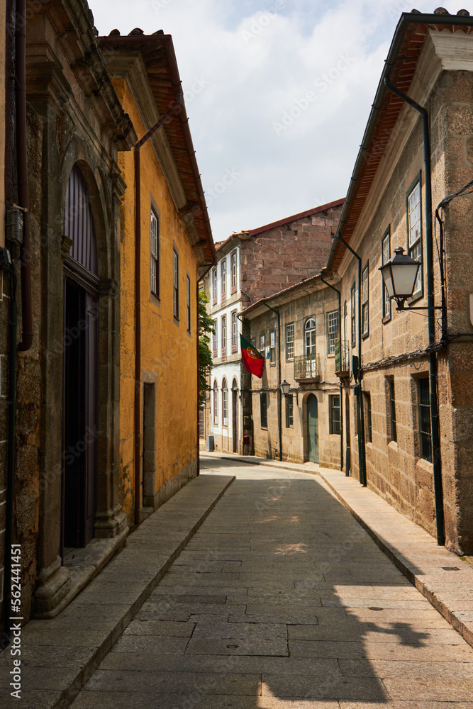 Street of ancient portuguese town with portuguese flag