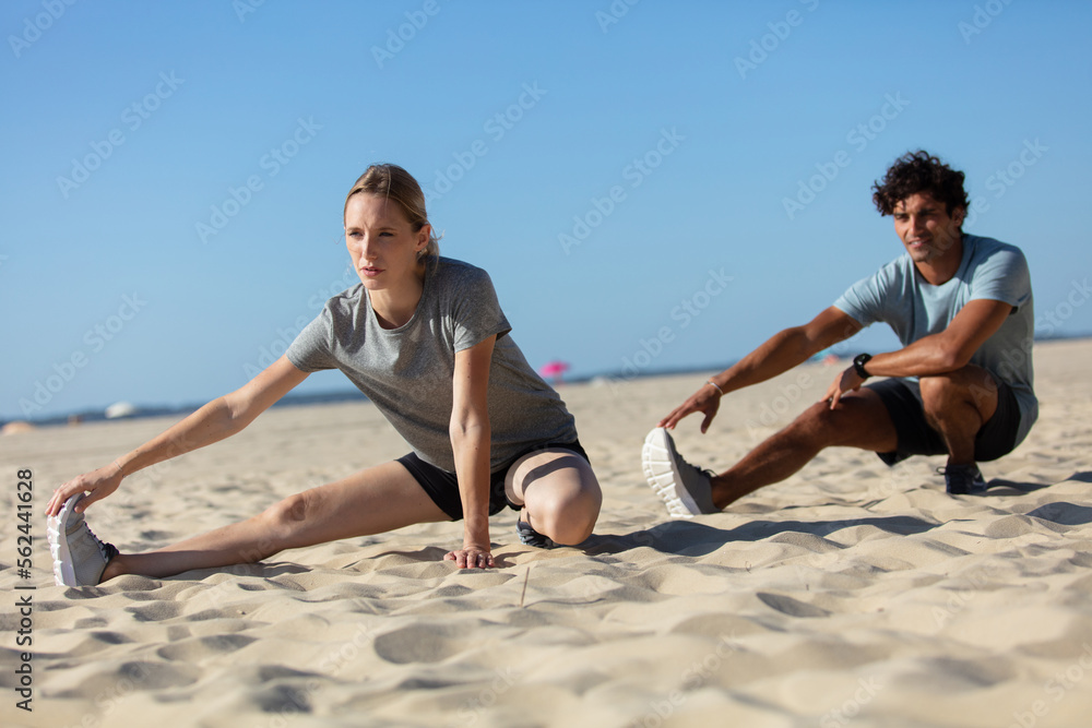 young couple exercising outdoors on the beach young couple exercising outdoors on the beach
