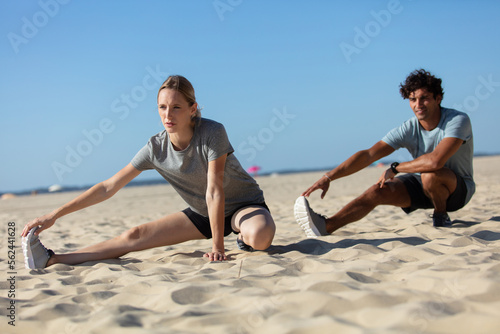 young couple exercising outdoors on the beach