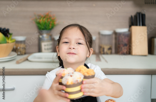 Portrait of a little girl in the kitchen of a house having fun playing baking bread