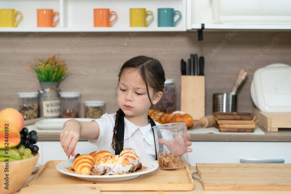 Portrait of a little girl in the kitchen of a house having fun playing baking bread Portrait of a little girl in the kitchen of a house having fun playing baking bread