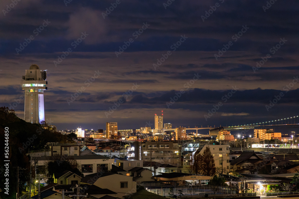 Dramatic sky over tower and dense quiet town in blue hour