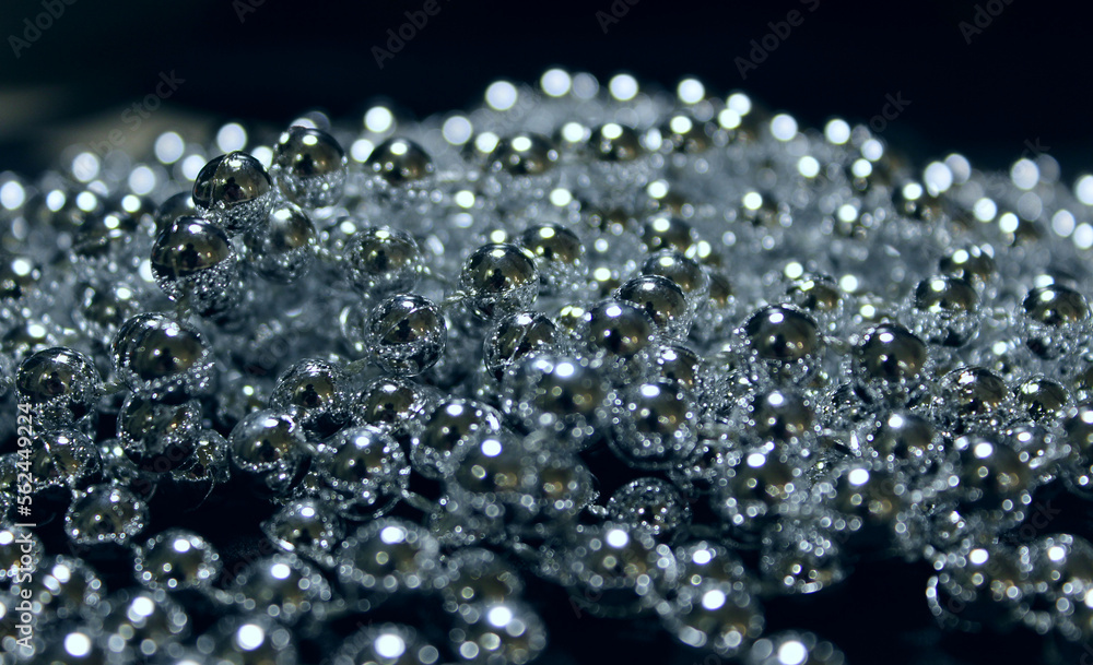 Shiny round elements glowing under light on a black background Shiny round elements glowing under light on a black background