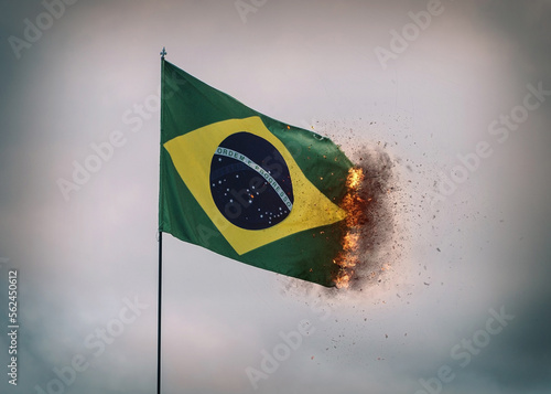 Brazil flag waving in a pole with fire and smoke on edges, digital composite photo