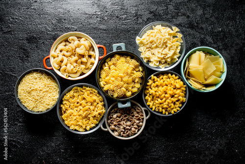 The range of different types of dry pasta in different bowls.