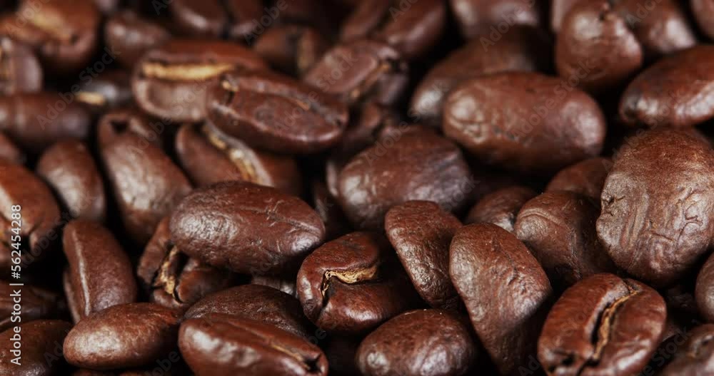 Roasted coffee beans dolly shot. Aromatic coffee beans move slowly. Slide slow motion close-up of whole roasted coffee beans. Roasted coffee beans dolly shot. Aromatic coffee beans move slowly. Slide slow motion close-up of whole roasted coffee beans.
