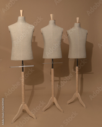 several empty mannequins on a light warm background 