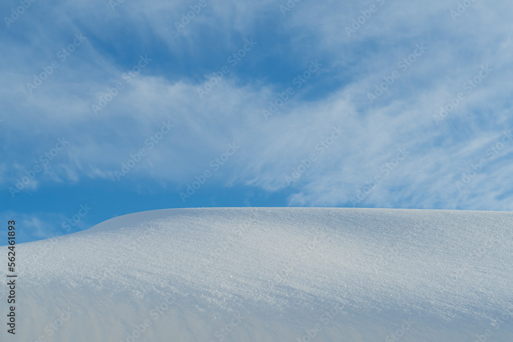 Blue sky with clouds and horizon from a snowdrift