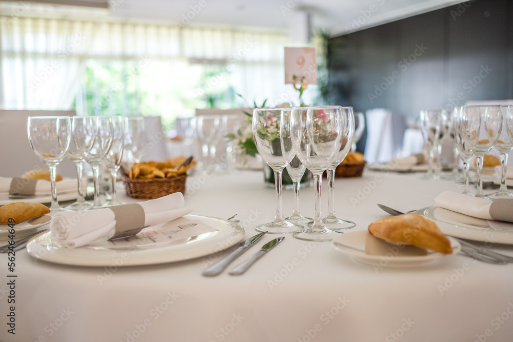 Wedding reception photo. Glasses and flowers on tables. 