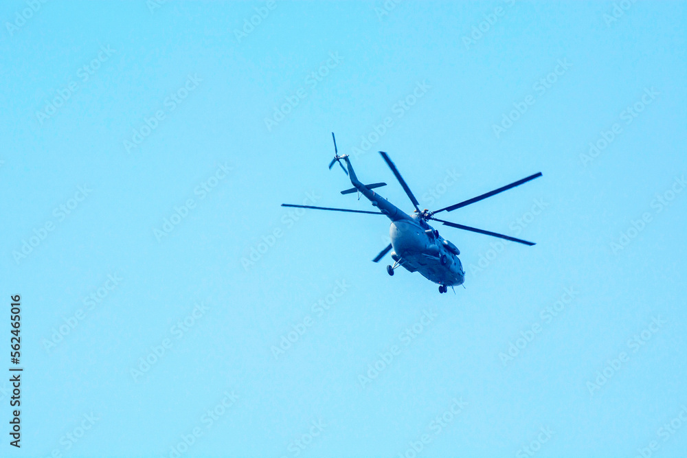 Combat helicopter is flying against isolated blue sky. Combat helicopter attack enemy. Combat helicopter is flying against isolated blue sky. Combat helicopter attack enemy.
