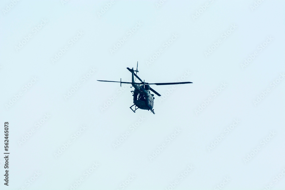 Combat helicopter is flying against isolated blue sky. Combat helicopter attack enemy Combat helicopter is flying against isolated blue sky. Combat helicopter attack enemy