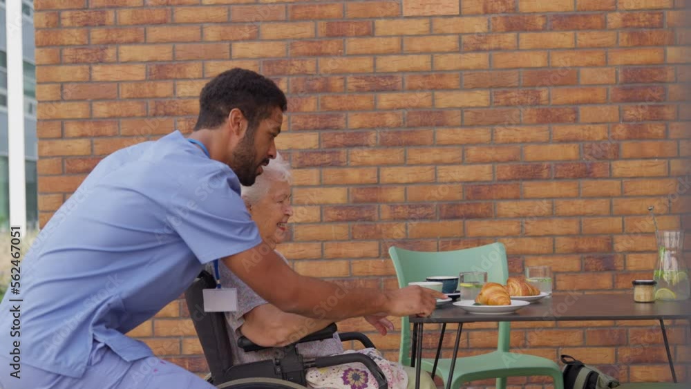 Caregiver taking his senior client at breakfast outdoor in the city. Caregiver taking his senior client at breakfast outdoor in the city.