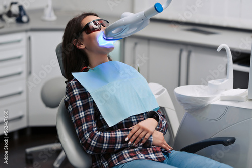 Teeth whitening for woman. Bleaching of the teeth at dentist clinic.