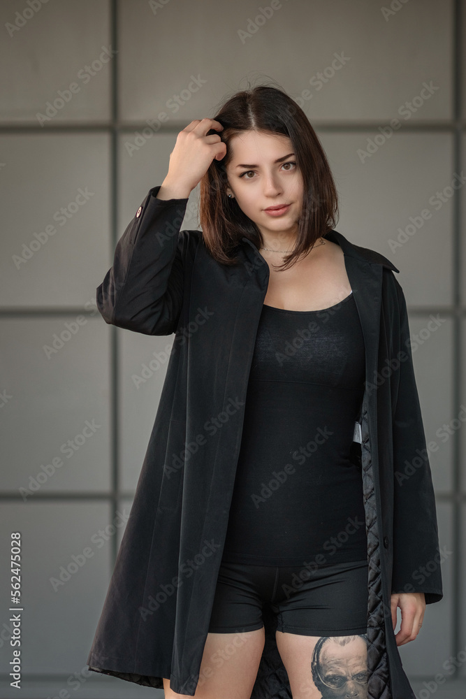 Dramatic close-up portrait of a dark-haired beautiful young girl on a gray background. Dramatic close-up portrait of a dark-haired beautiful young girl on a gray background.