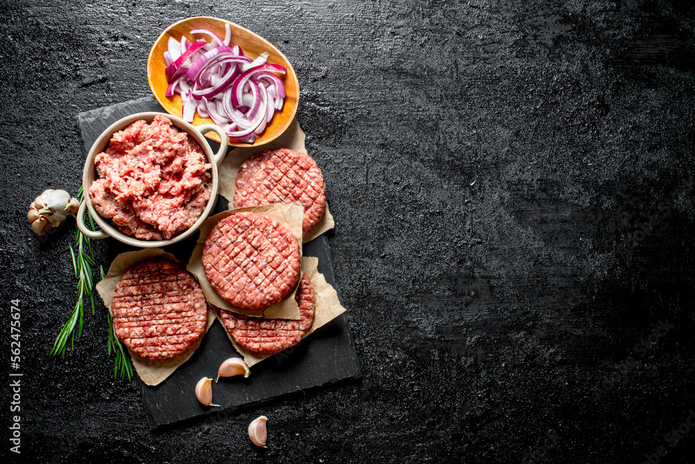 Raw burgers with ground beef and sliced onions in bowls.