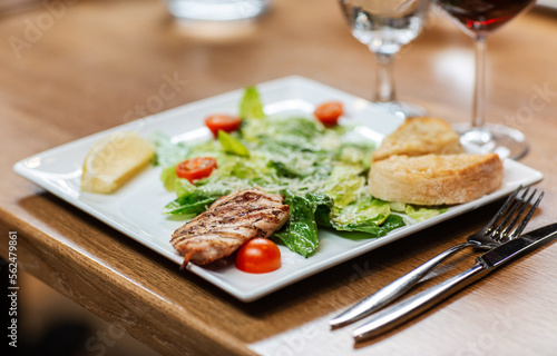 food and eating concept - close up of chicken with vegetable salad on plate at restaurant