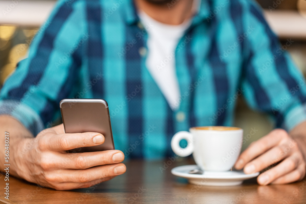 people, technology and leisure concept - close up of man drinking coffee and messaging on smartphone at restaurant or cafe people, technology and leisure concept - close up of man drinking coffee and messaging on smartphone at restaurant or cafe
