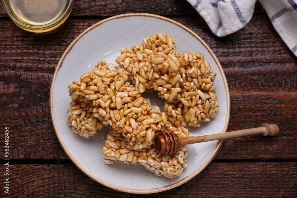 Plate with puffed rice bars (kozinaki) on wooden table, flat lay Plate with puffed rice bars (kozinaki) on wooden table, flat lay