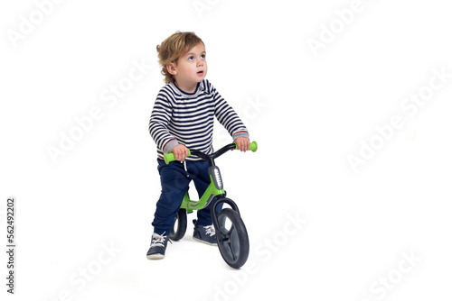 baby boy bicycling a bicycle and looking up on white background
