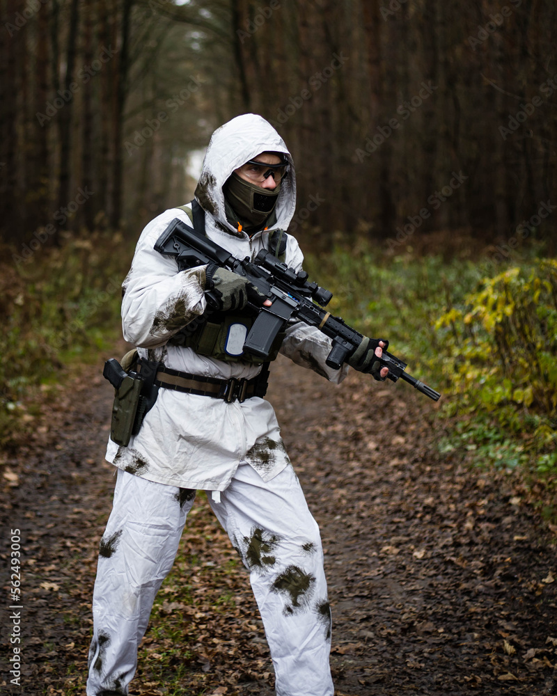 Man in a winter camo suit from side narrow shot.