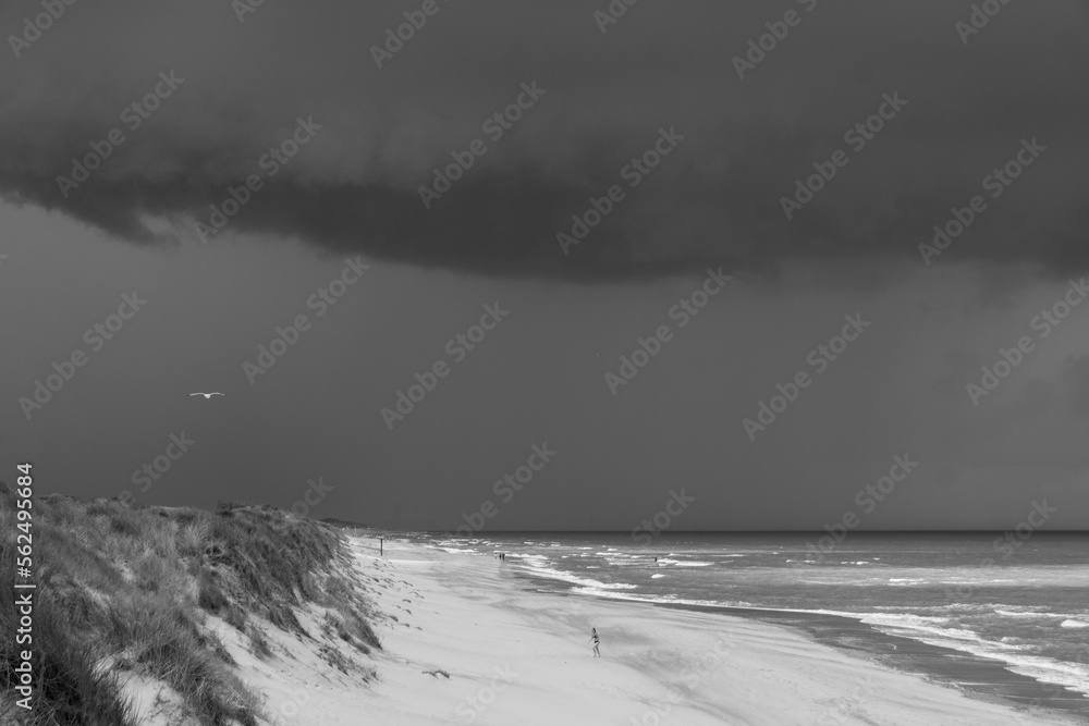silhouette sur une immense plage vide sous un ciel orageux au bord de la mer du Nord à Oostende en Belgique en été