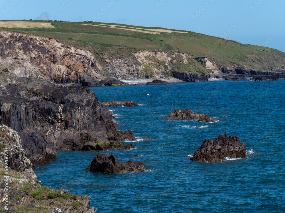 Irish sea landscape. Rocky coast of the Atlantic on a day. The blue sea, mountain beside body of water.