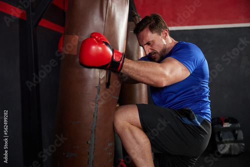 sportsman or fighter training with kick boxing punching bag in the gym