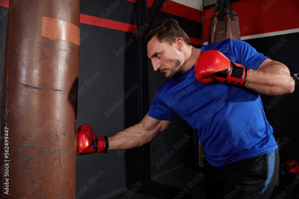 sportsman or fighter training boxing with punching bag in the gym