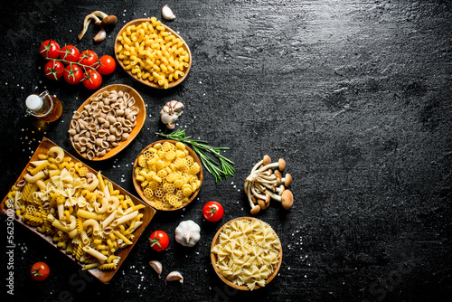 Different types of raw paste in bowls with mushrooms, rosemary and tomatoes.