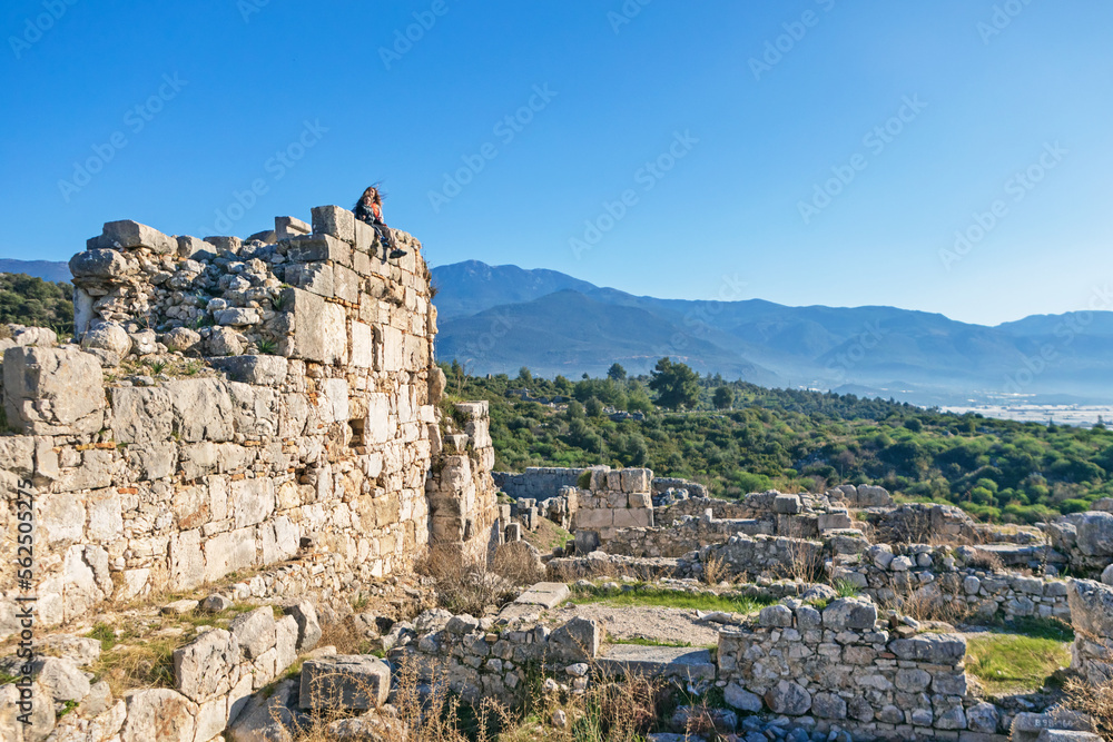 Mother with kids looking at acropolis of Xanthos ancient city - part of Lycian way. Largest city of Lycia. Popular travel destination in Antalya Turkey