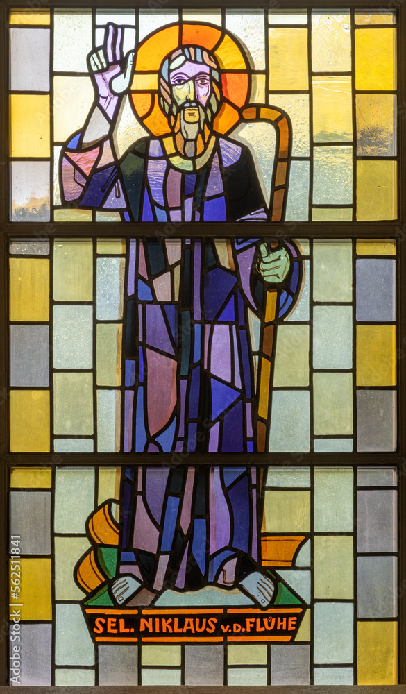TASCH, SWITZERLAND - JULY 2, 2022: The stained glass with the St. Nicolas of Flue in the parish church designed by August Wanner and made by Wilhelm Klotz from 20. cent.