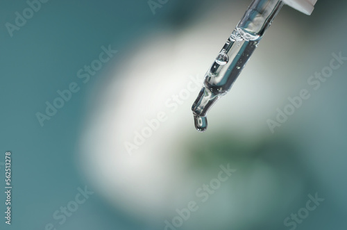 Closeup of face serum in transparent glass pipette. Natural oil, gel, cleaner. Anti age cosmetics and healthcare concept in macro. Dose of retinol. Virus research. Web banner for design