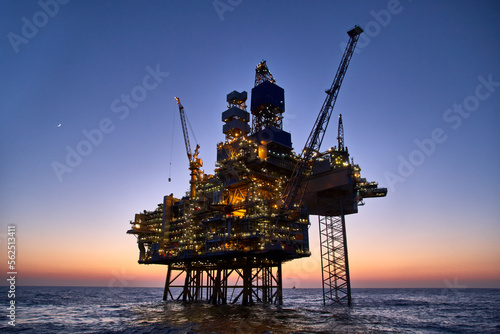 Offshore oil and gas platform in the sea at sunset. Jack up rig crude oil production in ocean.