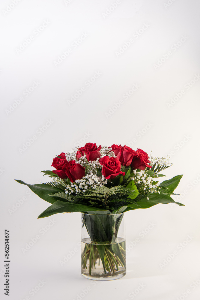 Red roses bouquet in a glass vase in white background