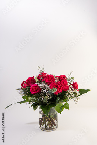 Red roses bouquet in a glass vase in white background