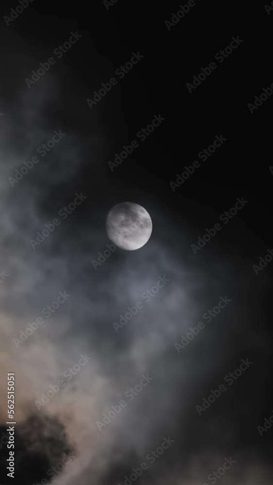 full moon moving between clouds. Vertical video full moon moving between clouds. Vertical video