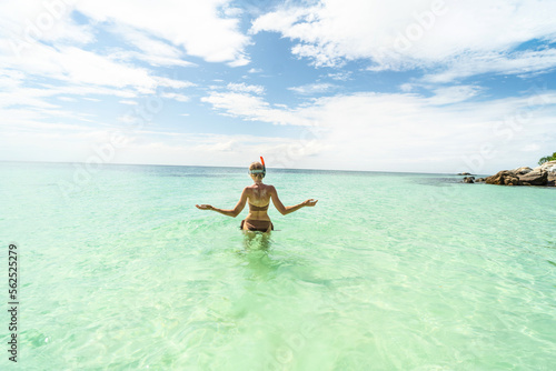Woman in a brown bikini snorkeling on Maldives. Back view. Tropical coastline. Tourist. Traveler. Hobby. Wanderlust