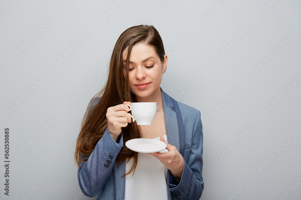 Business woman wearing suit holding coffee cup with saucer. Business woman wearing suit holding coffee cup with saucer.