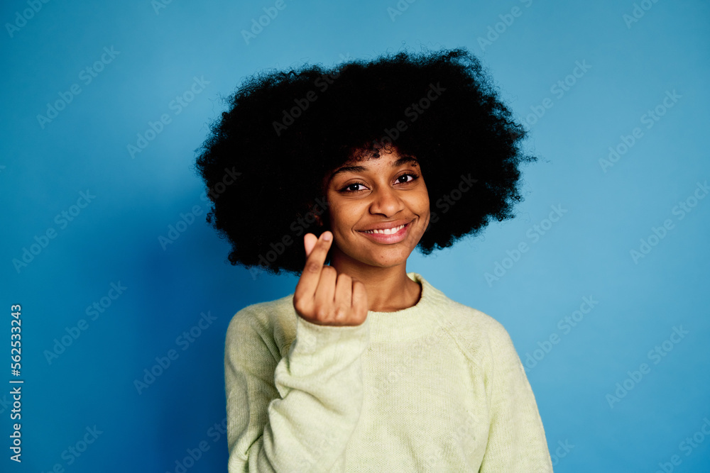 Cheerful black woman smiling and looking at camera doing the money signal Cheerful black woman smiling and looking at camera doing the money signal