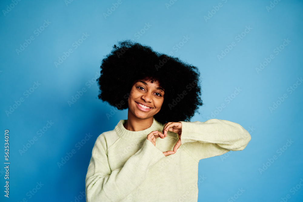 Smiling black woman showing a heart gesture Smiling black woman showing a heart gesture