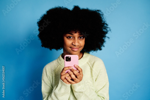 Smiling black woman using smartphone