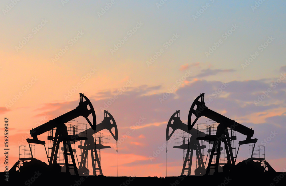 Oil drilling derricks at desert oilfield. Crude oil production from the ground. Oilfield services contractor. Oil drill rig and pump jack. Petroleum production, natural gas, liquids, NGL, additive.