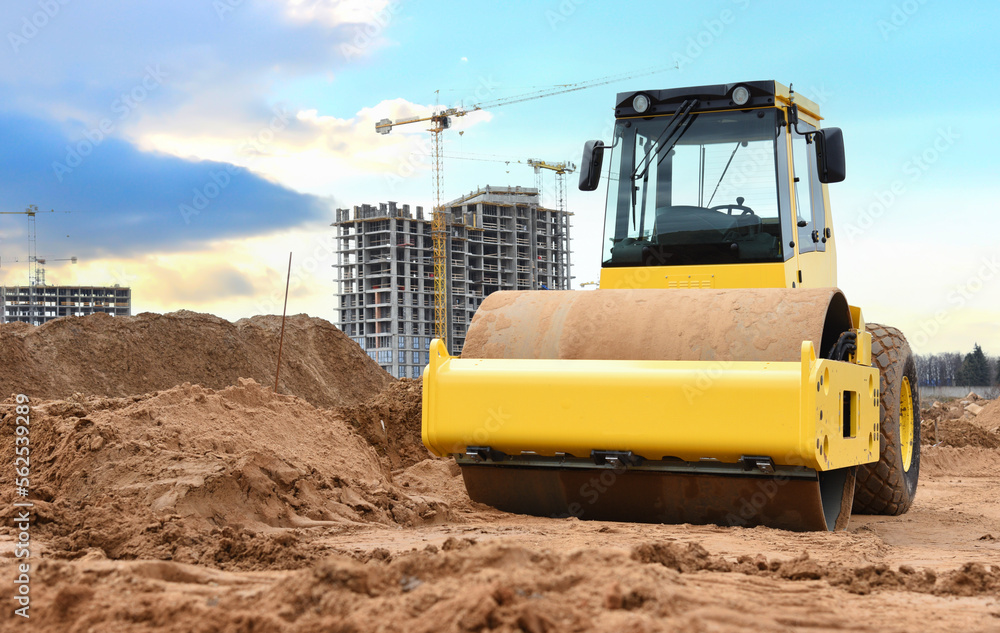 Soil Compactor for leveling ground for foundation and on road construction. Road compaction equipment at construction site. Vibration single-cylinder road roller on sunset. Building construction.