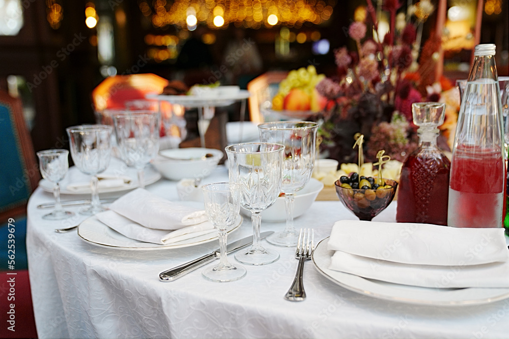 table setting for a festive dinner. empty wine glasses, tableware and snacks. table setting for a festive dinner. empty wine glasses, tableware and snacks.